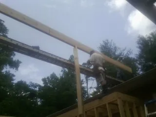 Carpenter setting a ridge beam over a new addition frame — Ice Dam Removal by Roofing Brothers in Ibapah