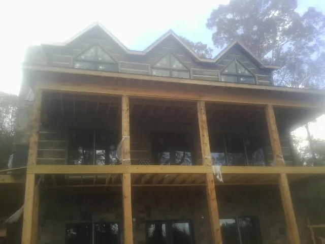 Dormers and porch framing on a large log home under construction — Roof Coating work by our crew in Ibapah