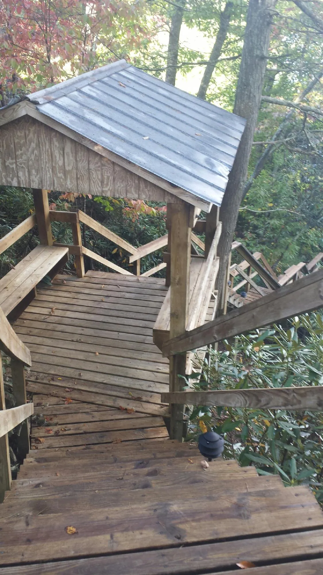 Metal roofed shelter over wooden steps on a wooded walkway — Skylight Repair & Installation work by our crew in Ibapah